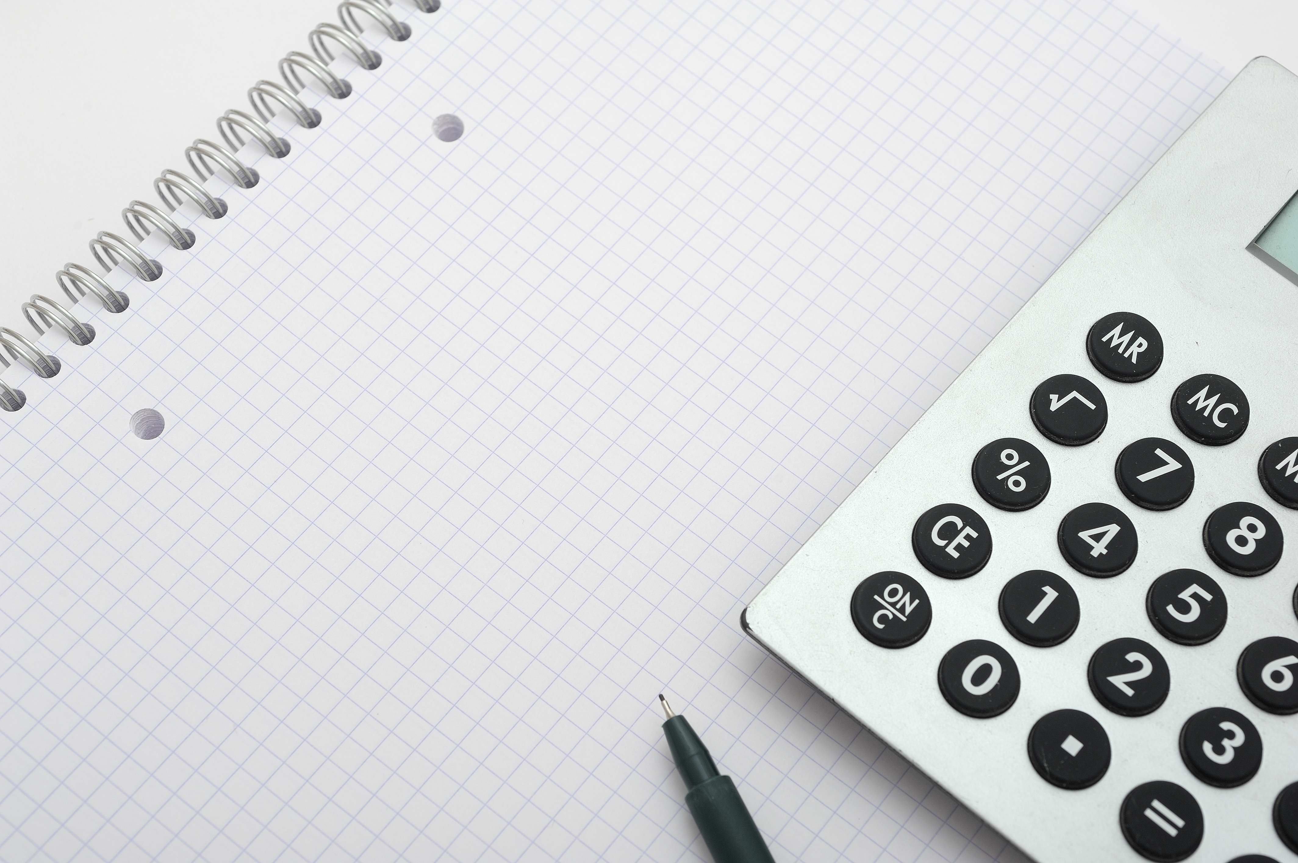 Blatt Schreibblock kariert mit Taschenrechner Stift